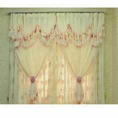 the curtains in this room are made of sheer fabric and have pink flowers on them