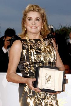 the woman is holding an award in her hand