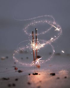 sparklers in the shape of a letter s on a table with rocks and pebbles