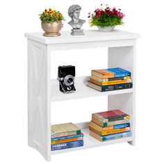 a white book shelf with books, camera and flowers sitting on top of each shelf