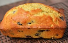 a loaf of blueberry bread on a cooling rack