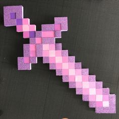 a piece of paper that is made to look like a pink and purple pixel block