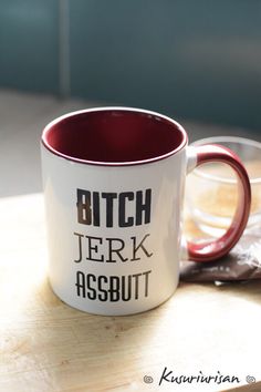 a white and red coffee mug sitting on top of a wooden table