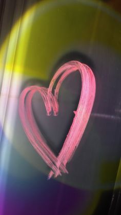 a pink heart drawn in the middle of a rainbow - colored background with light coming through it