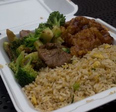 a plastic container filled with rice, meat and broccoli on top of a table