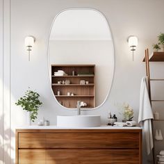 a bathroom with a large oval mirror above the sink and wooden cabinet below it, along with potted plants