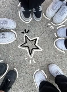 several people standing in a circle with their feet on the ground and one has a star drawn on it