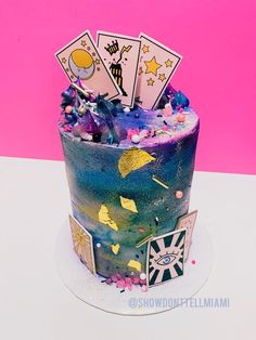 a colorful cake decorated with playing cards and confetti on the top is shown