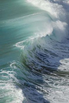 an ocean wave is breaking on the beach