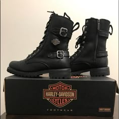 a pair of black harley davidson boots sitting on top of a box