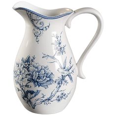 a blue and white pitcher with flowers on the bottom is sitting in front of a white background