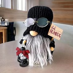 a small stuffed animal with glasses and a hat on it's head sitting on a table