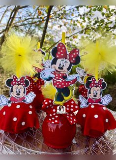 mickey and minnie mouse cupcake toppers on a cake platter with yellow feathers