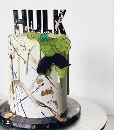 a decorated cake with the word hulk painted on it and splattered in paint