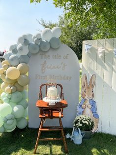 a birthday cake sitting on top of a wooden chair in front of a sign that says the tale of peter and his first birthday