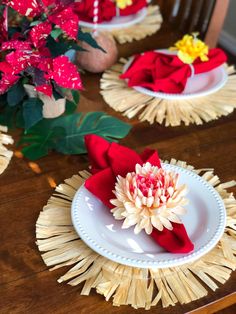 the table is set with red napkins and white plates, which have flowers on them