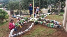 children are playing in the garden with plastic bottles