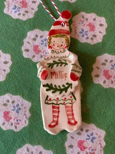 a ceramic ornament with a girl holding a christmas tree on it's back