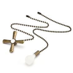 a cross necklace with two white beads on it