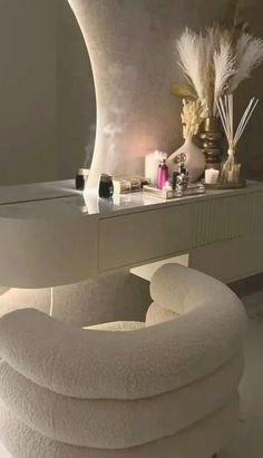 a white chair sitting in front of a mirror next to a table with candles on it