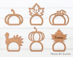 wooden cutouts with pumpkins, leaves and acorns are shown on a white background