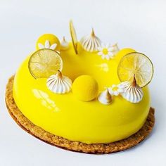 a yellow cake with lemons and white flowers on top is decorated with seashells