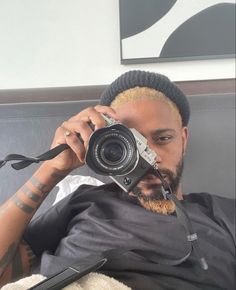 a man taking a selfie with his camera in front of him on the couch