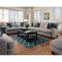 a living room filled with furniture and pillows on top of a hard wood floored floor