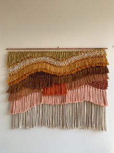 a wall hanging with fringes in different colors and patterns on it's side