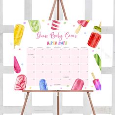 a calendar with popsicles and ice cream on it, next to a easel