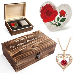 a wooden box with two red roses in it next to a necklace and ring case