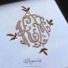 an embroidered monogram with leaves on it