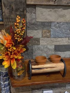 there is a vase with flowers and two bowls on the table