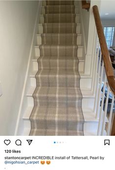 an image of a carpeted staircase with white railings and wood handrails