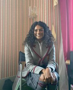 a woman sitting on top of a chair in a room