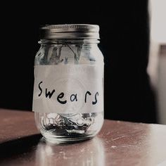 a glass jar with the word swears written on it