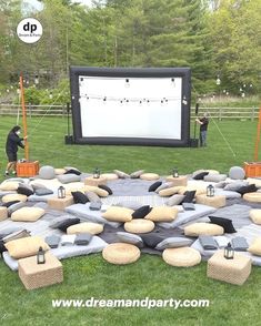 an outdoor movie screen is set up in the grass