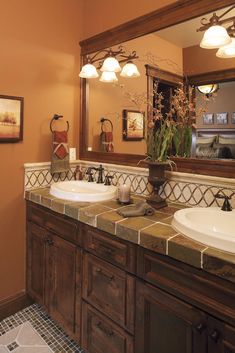 a bathroom with two sinks and a large mirror over it's counter top area