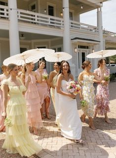 a group of women standing next to each other holding umbrellas