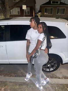 two people standing in front of a white van