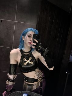 a woman with blue hair is taking a selfie in the mirror while holding a cell phone