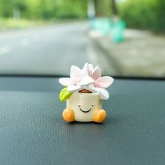 a toy car with a flower in the middle of it's dash board, sitting on top of a dashboard