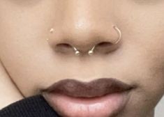 a close up of a person with piercings on their nose