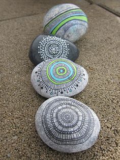 some rocks with designs on them are lined up in a row and sitting on the ground