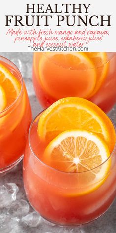 three glasses filled with orange juice and garnished with lemon