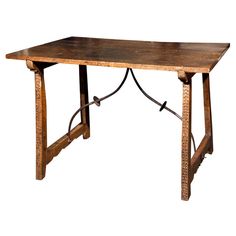 an old wooden table with metal legs and no one sitting at the top, on a white background