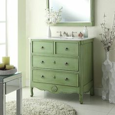 a bathroom with a green vanity and white rugs on the floor next to it