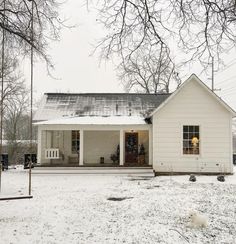 a white house sitting in the middle of a snow covered field