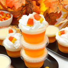 there are many desserts on the table with orange and yellow leaves in the background