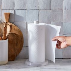 a person is holding a paper towel over a kitchen counter with utensils on it